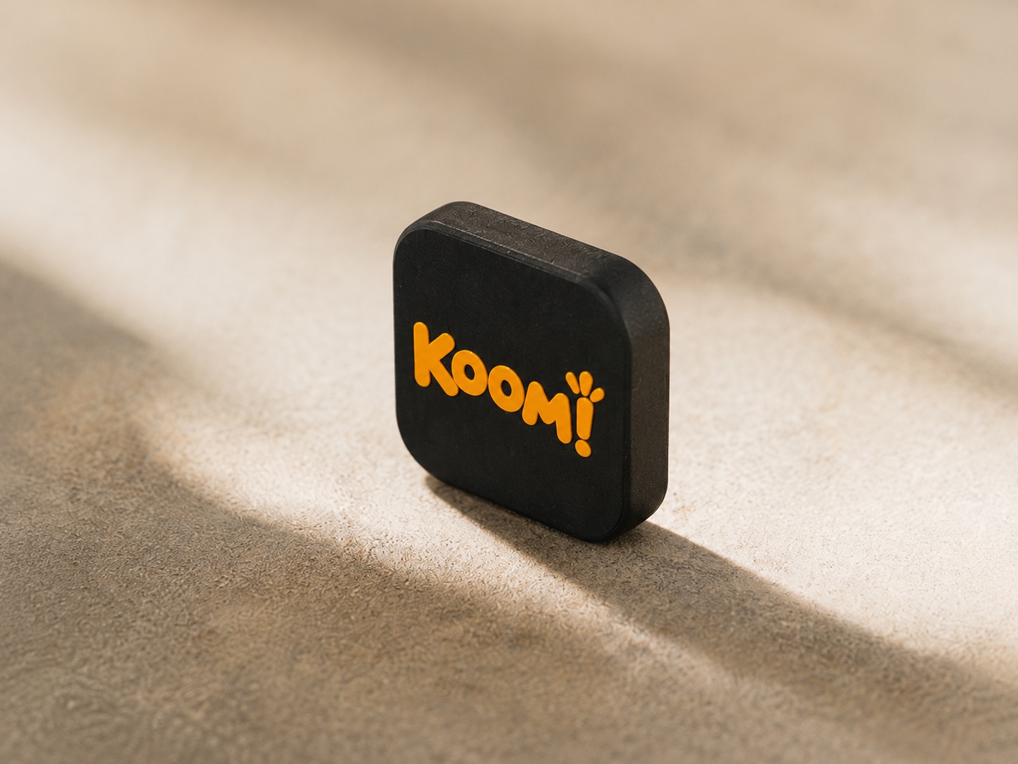 תג Koom!‎ עומד על משטח אבן, מואר באור בוקר רך